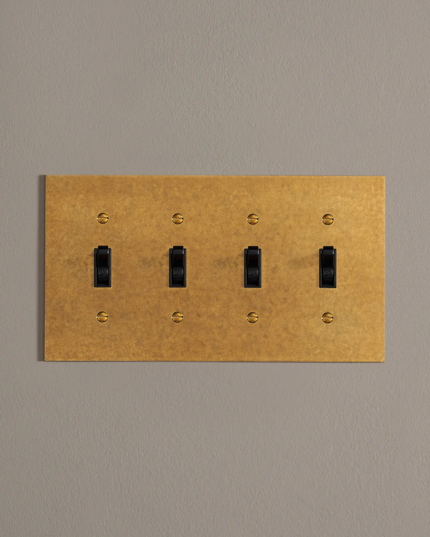 A front on shot on a toggle switch on an aged brass cover plate.