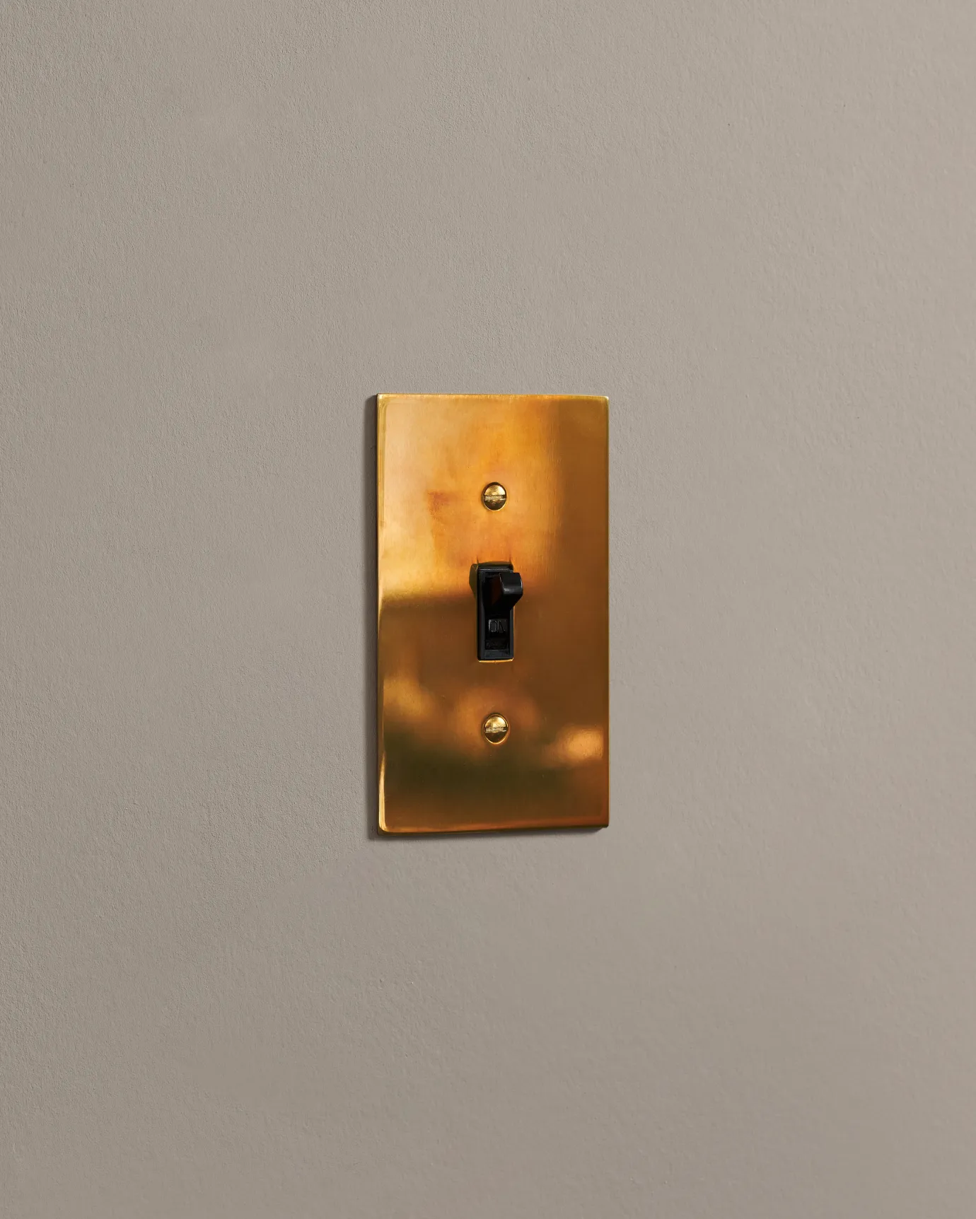a side on shot of the toggle switch on an heirloom brass cover plate.