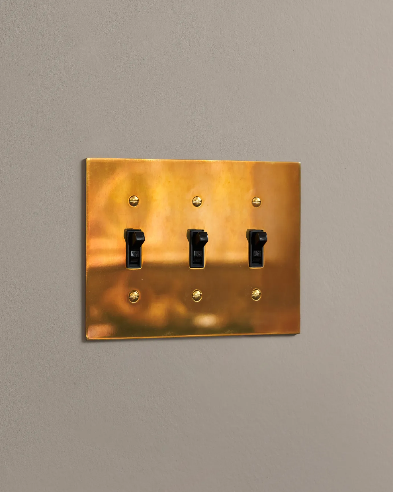 a side on shot of the toggle switch on an heirloom brass cover plate.