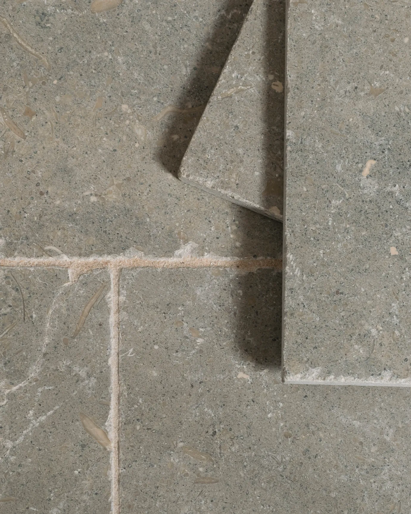 A close-up overhead view of Seagrass Tumbled Limestone flooring.